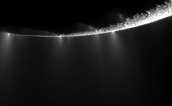 Plumes springing from Enceladus' surface spray water ice out from many locations along the “tiger stripes” near the moon's south pole. (c) NASA/JPL/SSI