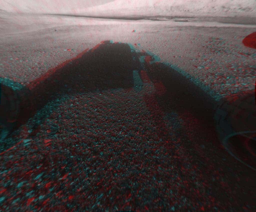 A 3-D rear-view vista that includes the rim of Curiosity's Gale Crater landing site. One of the rover's six big wheels is visible in the image's lower right. (c) NASA