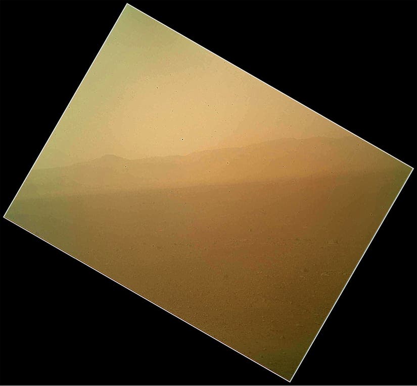 This image released on Tuesday Aug. 7,2012 by NASA shows the first color view of the north wall and rim of Gale Crater where NASA's rover Curiosity landed Sunday night. The picture was taken by the rover's camera at the end of its stowed robotic arm and appears fuzzy because of dust on the camera's cover. (AP Photo/NASA)