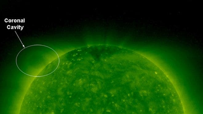 The faint oval hovering above the upper left limb of the sun in this picture is known as a coronal cavity. NASAs Solar and Terrestrial Relations Observatory (STEREO) captured this image on Aug. 9, 2007. The cavity has been the object of the study for three separate studies.  