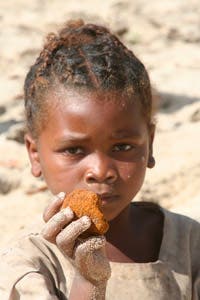 A young girl holds vato malemy, a reddish earth found in riverbeds throughout the Makira Protected Area of Madagascar. (c) Christopher Golden