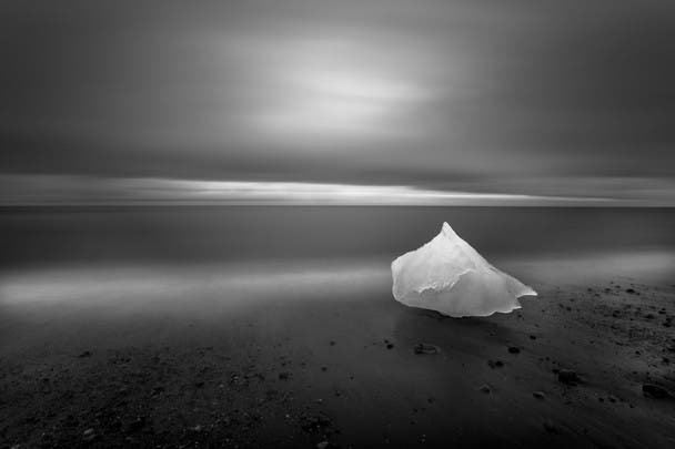 Photo and caption by Eric Guth  Glacial ice washes ashore after calving off the Breiðamerkurjökull glacier on Iceland's eastern coast. During the waning light of summer this image was created over the course of a 4 minute exposure while the photographer backlit the grounded glacial ice with a headlamp for 2 of those 4 minutes. Photo Location Just east of Jökulsárlón lagoon. Along Iceland's eastern coast.