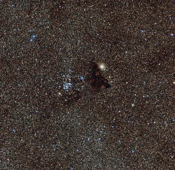 Billions of glowing stars from the brightest part of the Milky Way have been imaged this photo. At it's center lies a contrasting pair - a star cluster and a dark nebula. (c) ESO