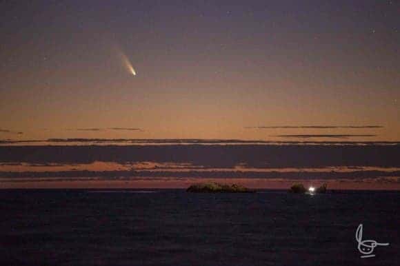 Comet Panstarrs at Burns Beach in northern metropolitan area in Perth, Western Australia. Rocks off the coast with birds and a small fishing boat. One hour after sunset in early March. (C) Michael Goh