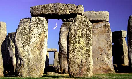 Stonehenge with a new moon seen through standing stones