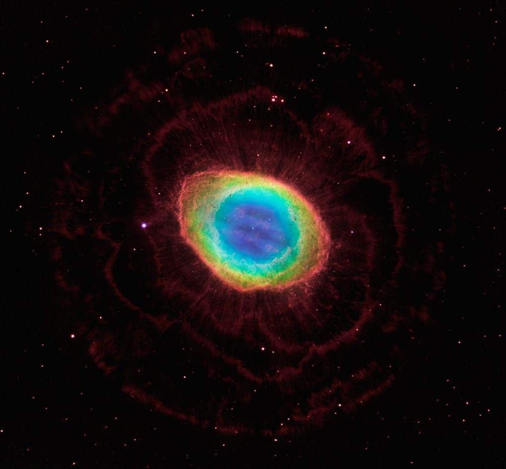 Not too long ago, the Ring nebula was thought to be shaped like a sphere. New Hubble observations, coupled with ground imaging, show that the nebula is actually shaped like a bagel. In the image, the deep blue color in the center represents helium; the cyan color of the inner ring is the glow of hydrogen and oxygen; and the reddish color of the outer ring is from nitrogen and sulfur. (c) NASA