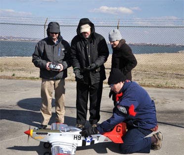 Flying a radio-controlled replica of the historic WWII P-51 Mustang red-tail aircraft—of the legendary Tuskegee Airmen—NRL researchers (l to r) Dr. Jeffrey Baldwin, Dr. Dennis Hardy, Dr. Heather Willauer, and Dr. David Drab (crouched), successfully demonstrate a novel liquid hydrocarbon fuel to power the aircraft's unmodified two-stroke internal combustion engine. The test provides proof-of-concept for an NRL developed process to extract carbon dioxide (CO2) and produce hydrogen gas (H2) from seawater, subsequently catalytically converting the CO2 and H2 into fuel by a gas-to-liquids process. - See more at: http://www.nrl.navy.mil/media/news-releases/2014/scale-model-wwii-craft-takes-flight-with-fuel-from-the-sea-concept#sthash.mM6Ly1SP.dpuf