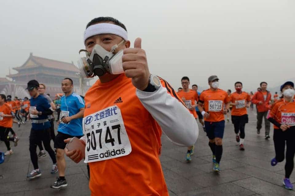 Despite the air pollution, one man gives a thumbs-up in front of Tiananmen Square on Oct. 19, 2014. Image via Reuters