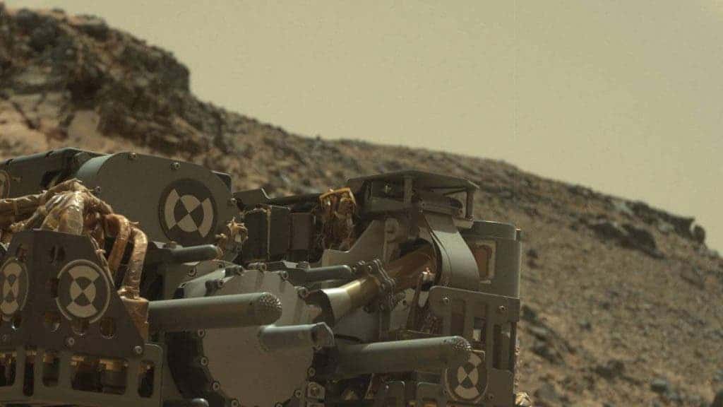 This raw-color view from Curiosity's Mastcam shows the rover's drill just after finishing a drilling operation at 