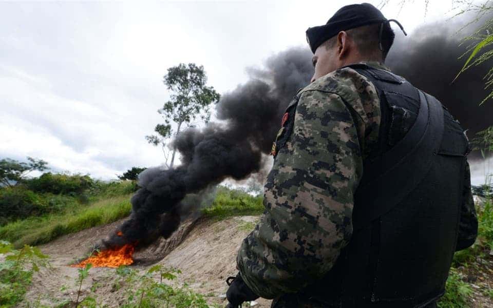 A soldier stands guard as 420 kilos of cocaine seized in La Mosquitia in Honduras are incinerated by the organized crime public prosecutor’s office, in Tegucigalpa, in October 2013.Orlando Sierra / AFP / Getty Images