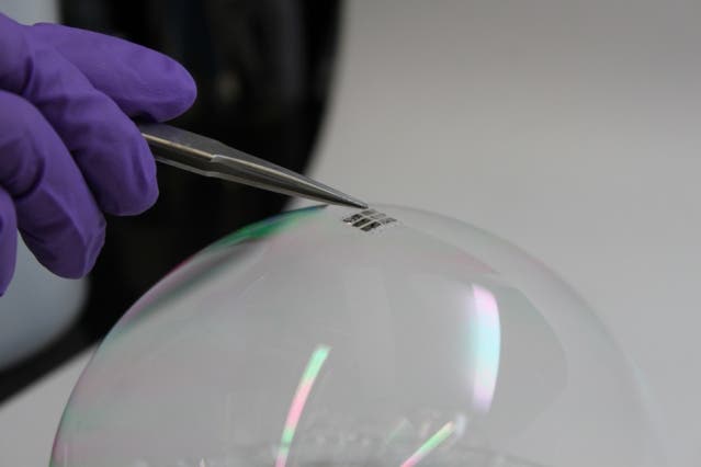 To demonstrate just how thin and lightweight the cells are, the researchers draped a working cell on top of a soap bubble, without popping the bubble. 
Image credits Joel Jean and Anna Osherov / MIT