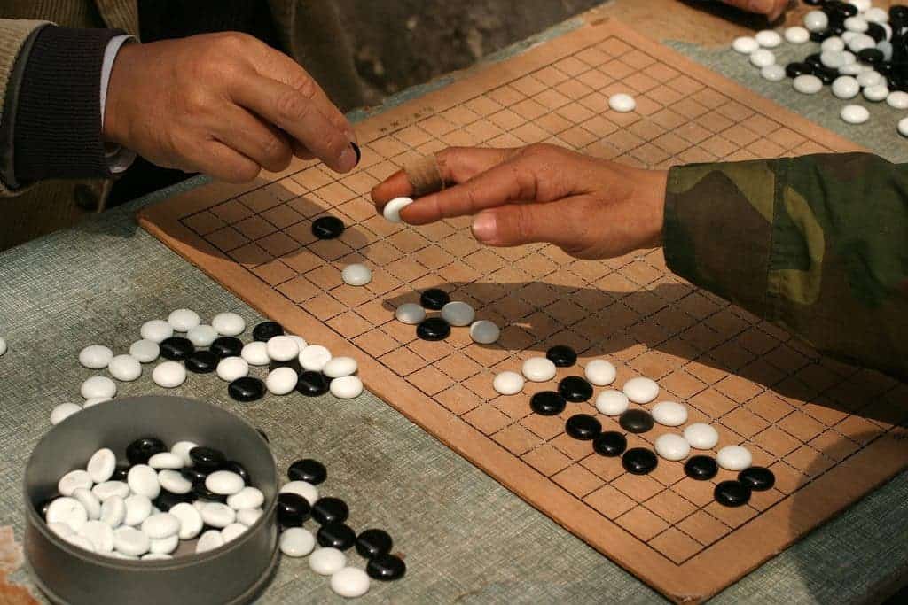 Go players in Shanghai demonstrate the traditional technique of holding a stone.