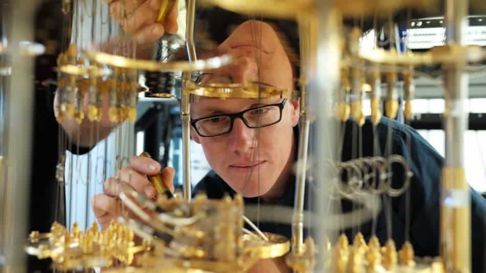 IBM scientist Stefan Filipp, takes a closer look at the dilution refrigerator which will keep qubits are temperatures colder than the deepest parts of outer space. Image credits: IBM, via Mashable.
