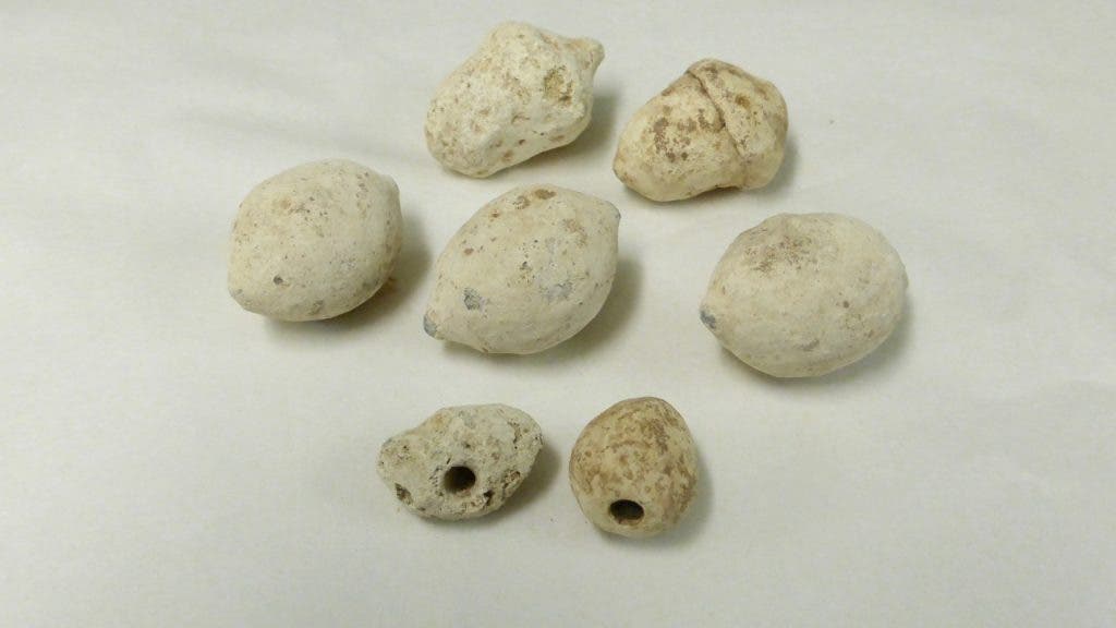 Samples of Roman slingshot bullets found at the Burnswark Hill site. The bottom two with holes drilled belong to Type III and produced a whistling sound. Credit: John Reid/Trimontium Trust