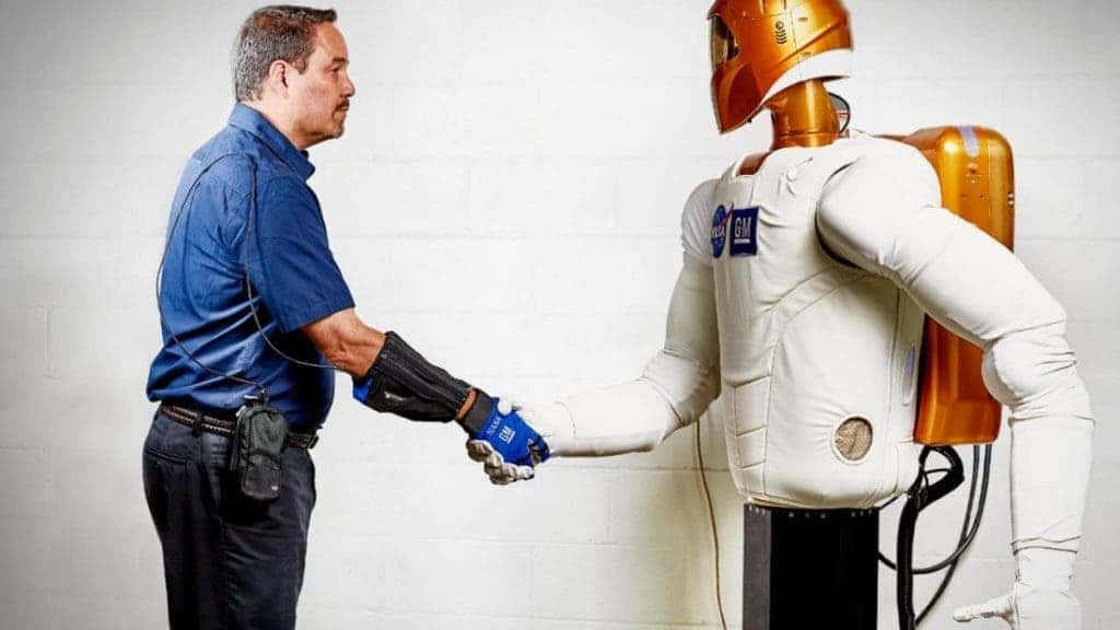 GM principal engineer for robotics Marty Linn wearing the RoboGlove shakes hands with Robonaut 2.
Image credits NASA/GM