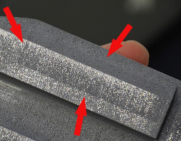 The red arrows point to an area with a slightly different texture than the rest of the metal body. Those are actually very tiny channels that help ooze water to the surface. Credit: JSK Lab/University of Tokyo