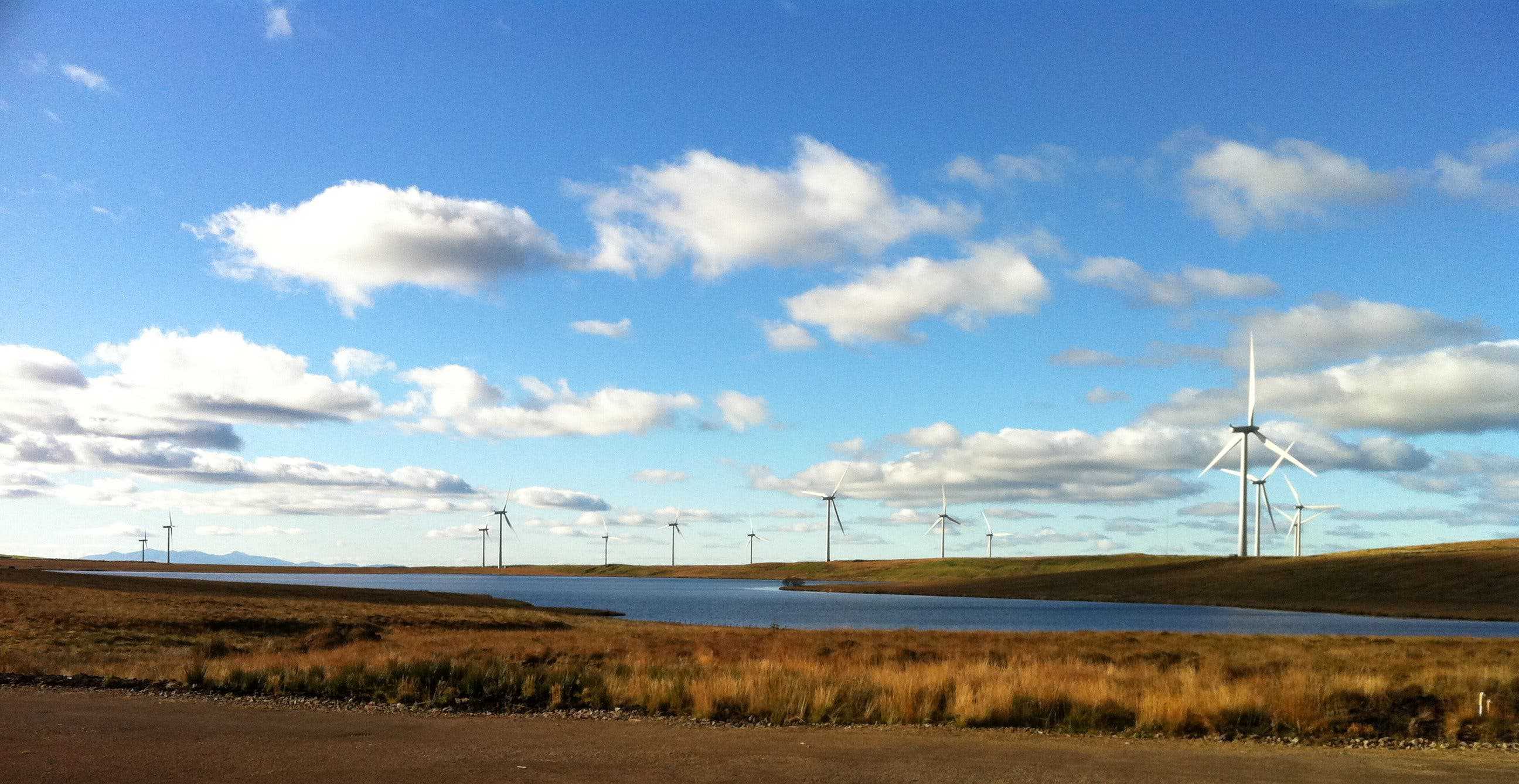 Whitelee Wind Farm with the Isle of Arran in the background. Photo by Bjmullan