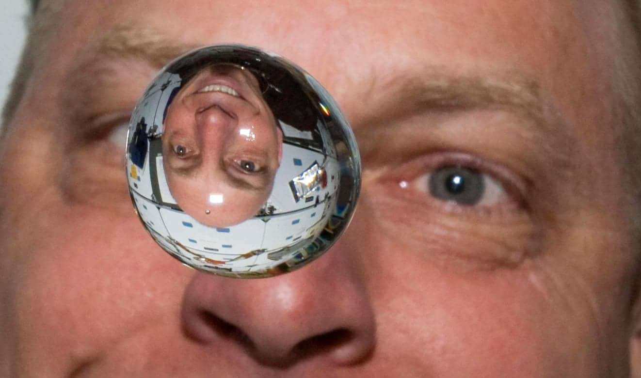 Astronaut Clayton Anderson facing a water bubble in 0 G aboard Discovery.
Image credits NASA.