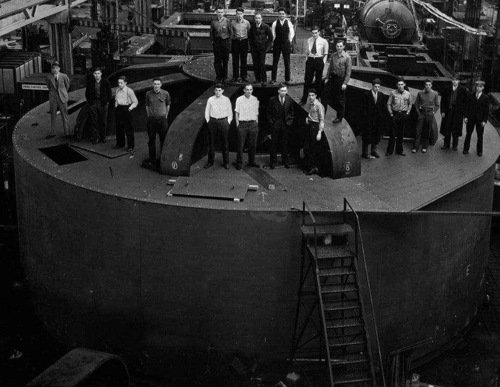 Engineering students pose for a picture atop one of the 2 million-pound hydroelectric generators for the dam at the General Electric factory in Schenectady, New York (1935).