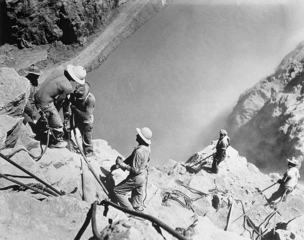 To make sure the canyon walls were solid enough to support the arch design, so-called 'high scalers' were employed to hammer away anything loose. Falling rocks were a serious hazard so the workers dripped their hats in tar and left them out to dry. Essentially, these were some of the first hard hats. Credit: Corbis