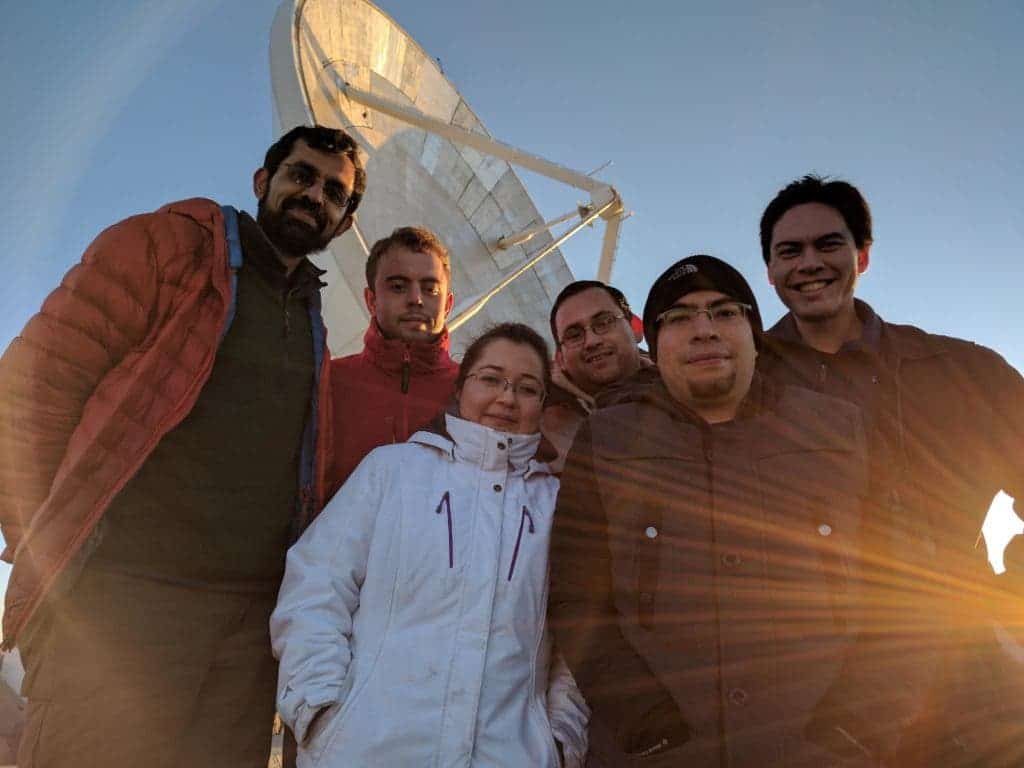 EHT team posing for a picture with the massive LMT radio dish in the background. Credit: UMassAmherst.