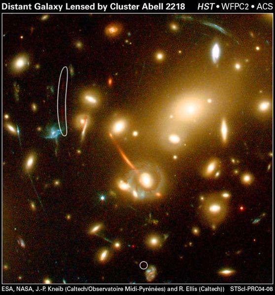 Those are actually background galaxies that get distorted and magnified by the giant cluster which bends the light. That’s analogous to how normal lenses such as the ones in a magnifying glass or a pair of spectacles work by bending light rays that pass through them in a process known as refraction, in order to focus the light somewhere (such as in your eye). Credit: ESA, NASA, J.-P. Kneib and Richard Ellis. 