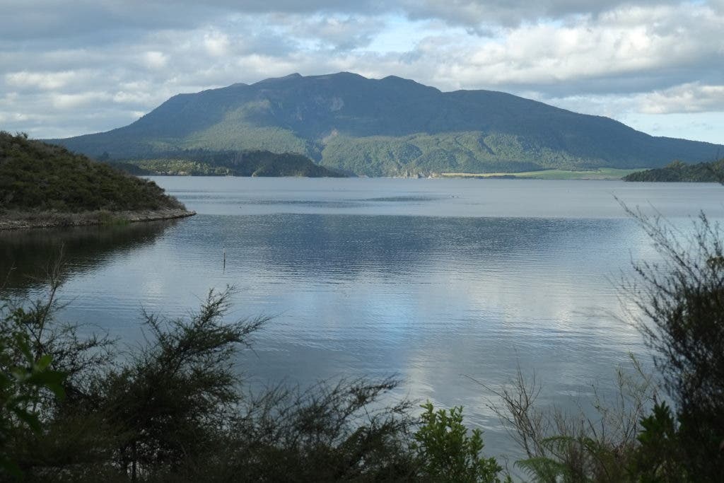 Lake Rotomahana, with Mount Tarawera in the background. Somewhere beneath the water lie the lost terraces. Credit: Wikimedia Commons.