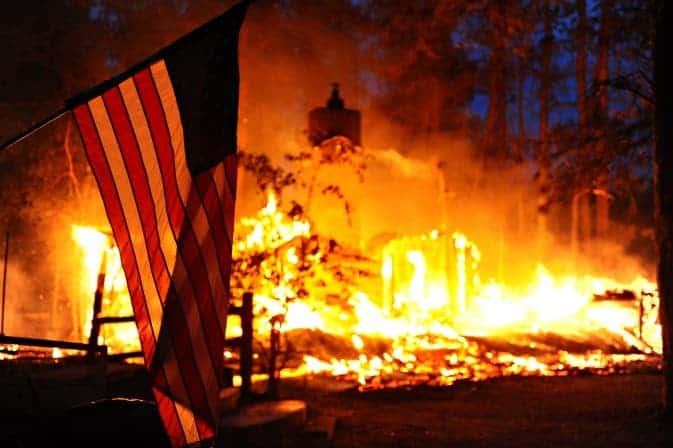 A U.S. flag hangs in front of a burning structure during the 2013 wildfires. Image credits: NASA.