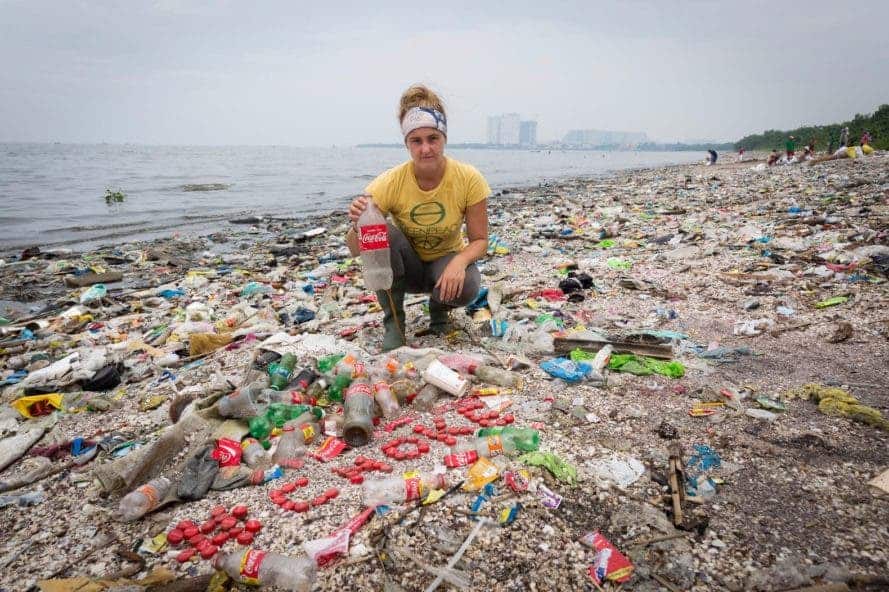 Greenpeace Canada Oceans campaigner Sarah King with a collection of Coca-Cola bottles and caps found on Freedom Island, Philippines. Photograph: Daniel Müller/Greenpeace.
