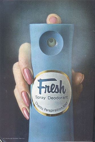 Woman's hand holding deodorant facing camera