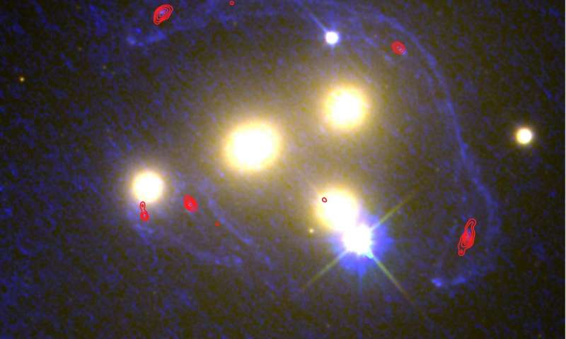 A view of the four central galaxies at the heart of cluster Abell 3827, at a broader range of wavelengths, including Hubble Space Telescope imaging in the ultraviolet (shown as blue), and Atacama Large Millimetre Array imaging at very long (sub-mm) wavelengths (shown as red contour lines). Credit: NASA/ESA/ESO/Richard Massey.