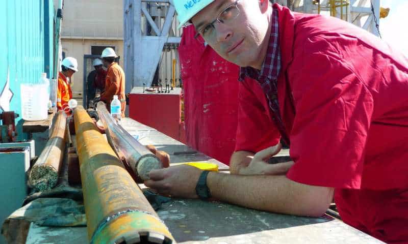 Associate Professor Jody Webster on board the Great Ship Maya with a fossil core from the Great Barrier Reef. Credit: ECORD/IODP.