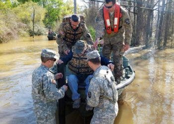 Members of the Louisiana National Guard's 2225th Multi-Role Bridge Company, 205th Engineer Battalion help a resident from Watters Road just outside Ponchatoula, La., out of the bridge erection boat (BEB) they used to go door-to-door to check on residents that could not get out of their homes, March 13, 2016. The river had overcome its banks and flooded the road. The current of the river was too strong for regular boat motors to battle.
