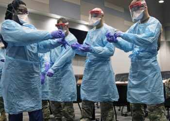 Members of the Florida National Guard (FLNG) gather with local hospital staff to collaborate on donning and doffing personal protective equipment (PPE) during Task Force – Medicals’ response to the COVID-19 virus, March 17, 2020. The FLNG is mobilizing up to 500 Citizen-Soldiers and Airmen in support of the Florida Department of Health response in Broward County. (U.S. Army photo by Sgt. Leia Tascarini)