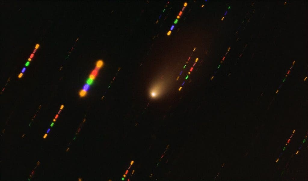 This image was taken with the FORS2 instrument on ESO’s Very Large Telescope in late 2019, when comet 2I/Borisov passed near the Sun. Since the comet was travelling at breakneck speed, around 175 000 kilometres per hour, the background stars appeared as streaks of light as the telescope followed the comet’s trajectory. The colours in these streaks give the image some disco flair and are the result of combining observations in different wavelength bands, highlighted by the various colours in this composite image. (ESO/O. Hainaut)