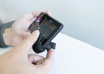 A person measuring blood pressure using the BP clip.