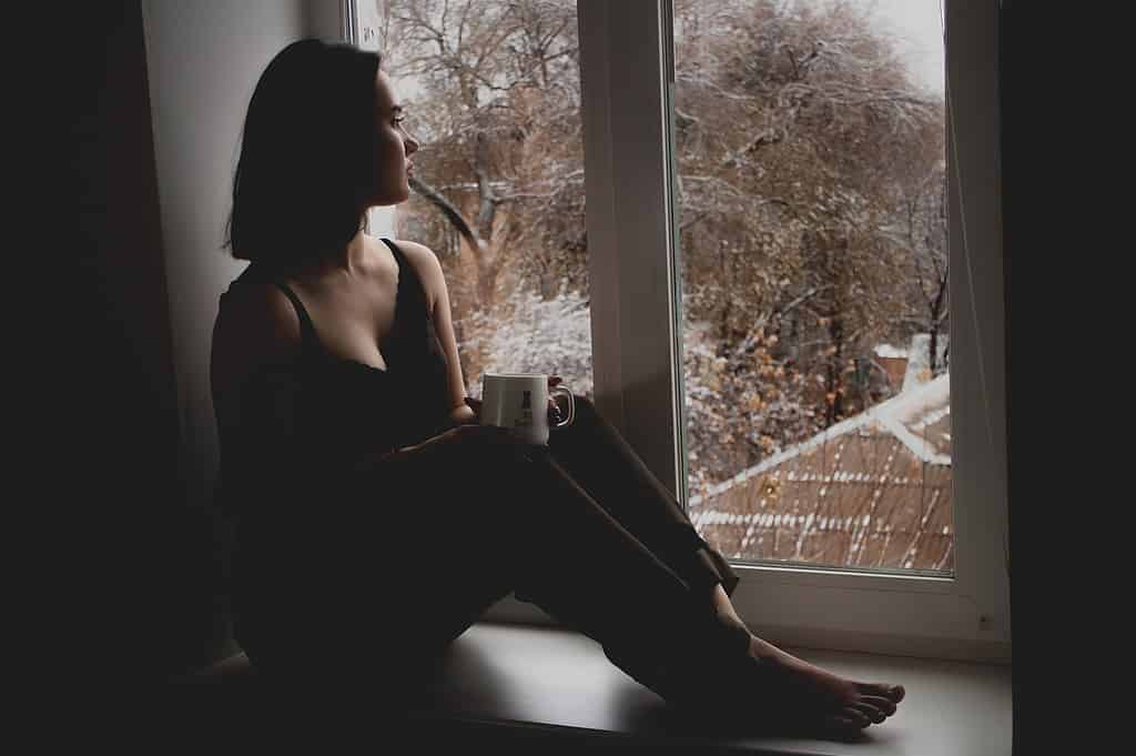 Depressed woman looking out window