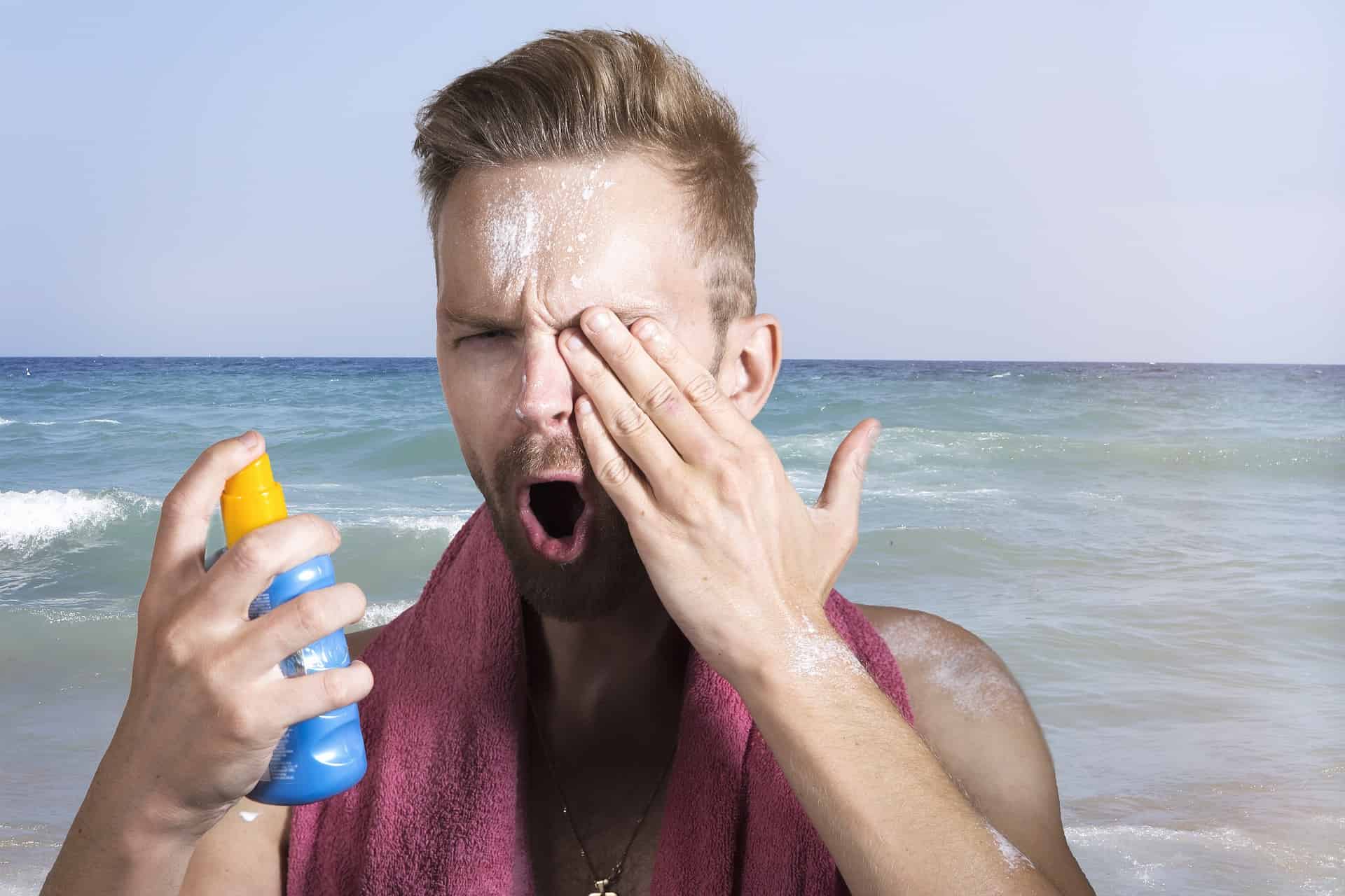 Man applying sunscreen face beach