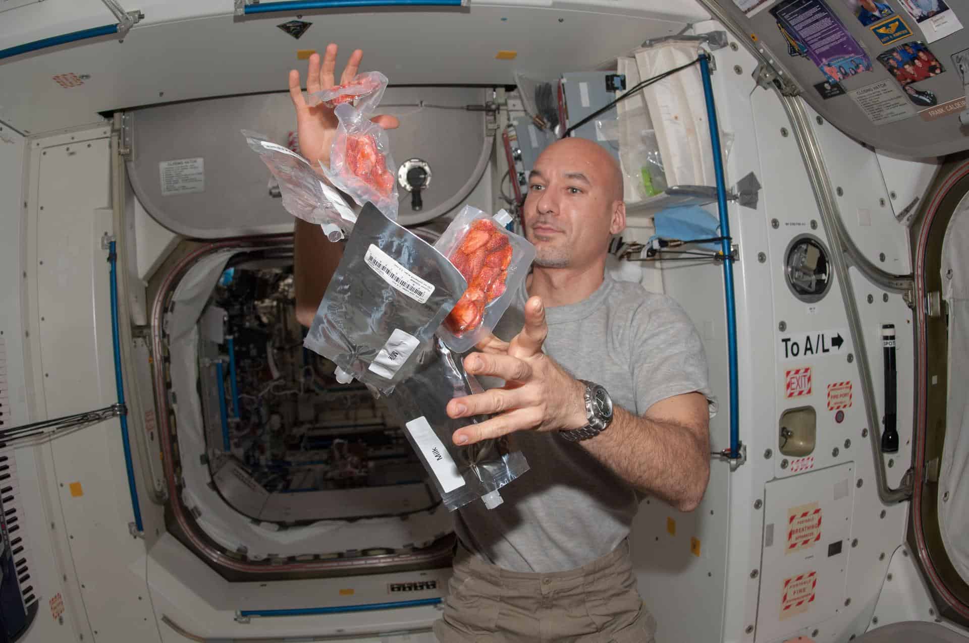 astronaut handling floating food in sapce