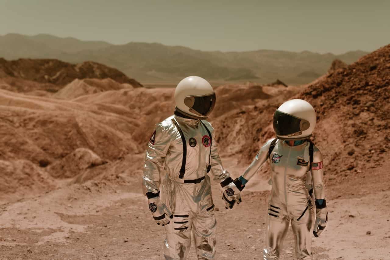 male and female astronauts holding hands on Mars