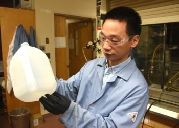 Guoliang Liu holds a common water jug in his lab at Hahn Hall South. Image credits: Steven Mackay / Virginia Tech.