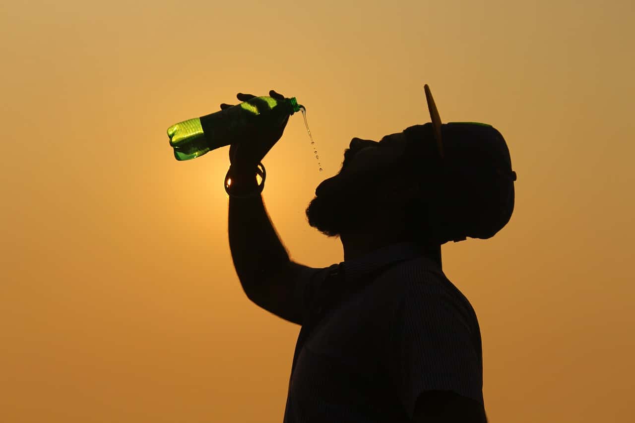 Man drinking water from plastic bottle