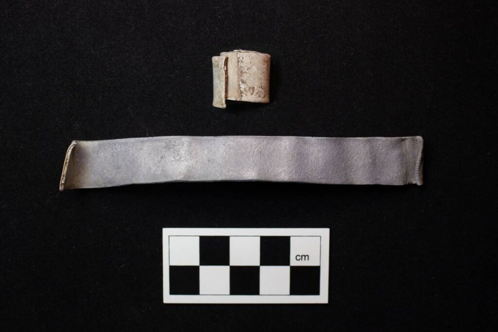 A rolled scroll sits next to an unrolled scroll. Credit: Red River Archaeology Group.